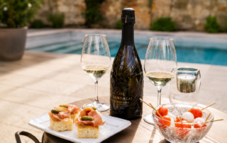 Bottiglia di Prosecco Col Sandago Valdobbiadene DOCG con calici e aperitivo, disponibile presso Il Coffee Shop di Genova